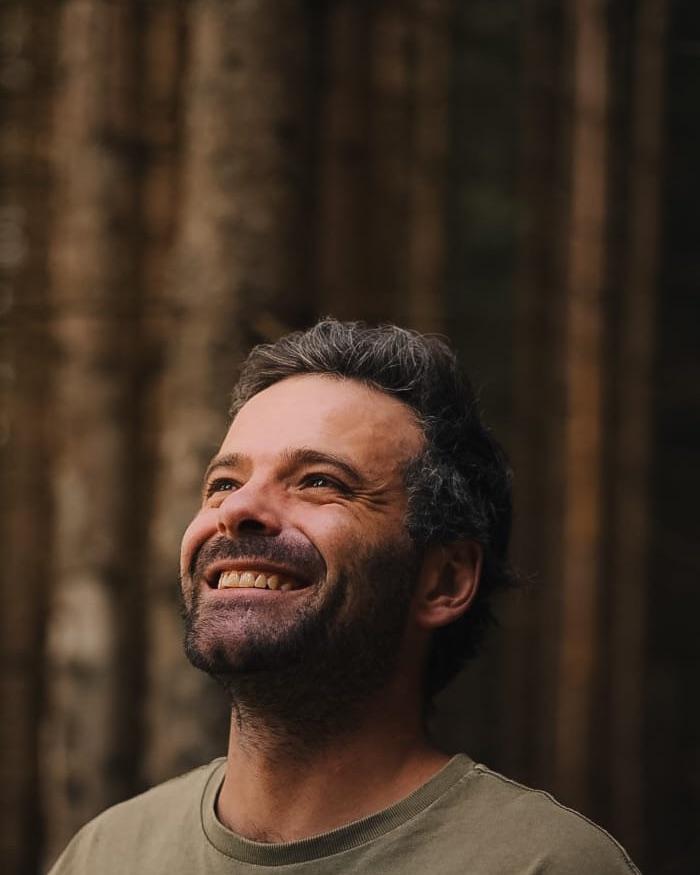 Mathieu Dupont-Vieux in a conifer wood, looking up.